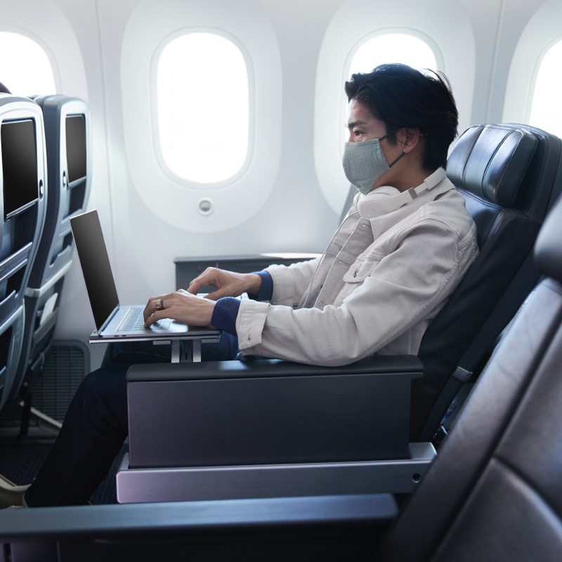 A man works on his laptop during a flight